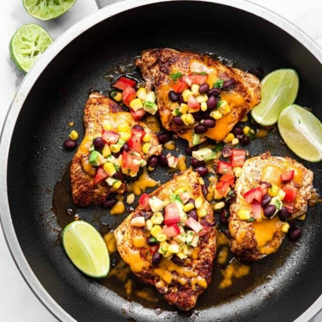 santa fe chicken in a skillet with cheese and black bean salsa