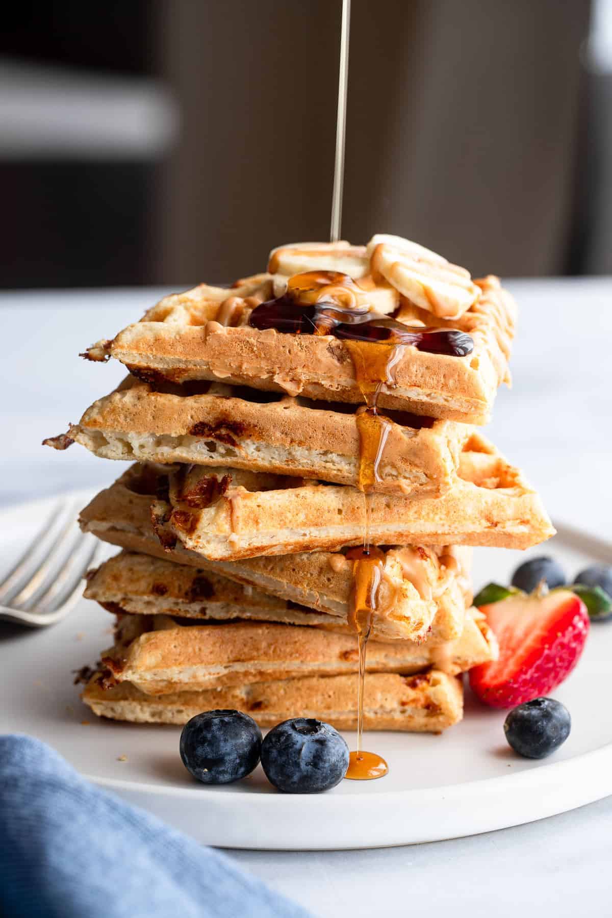 a stack of protein waffles drizzled with maple syrup