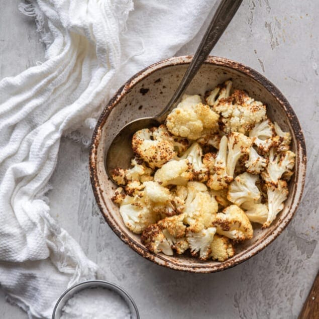 air fryer cauliflower in small bowl with spoon