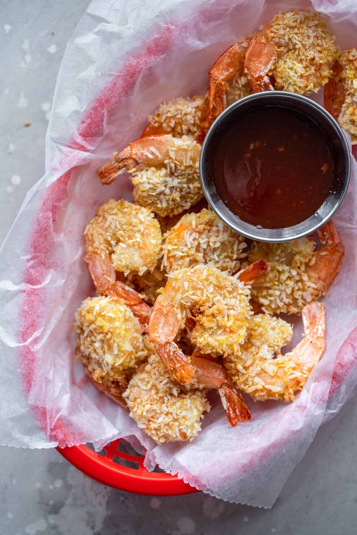 Coconut shrimp air fryer in a basket with sauce