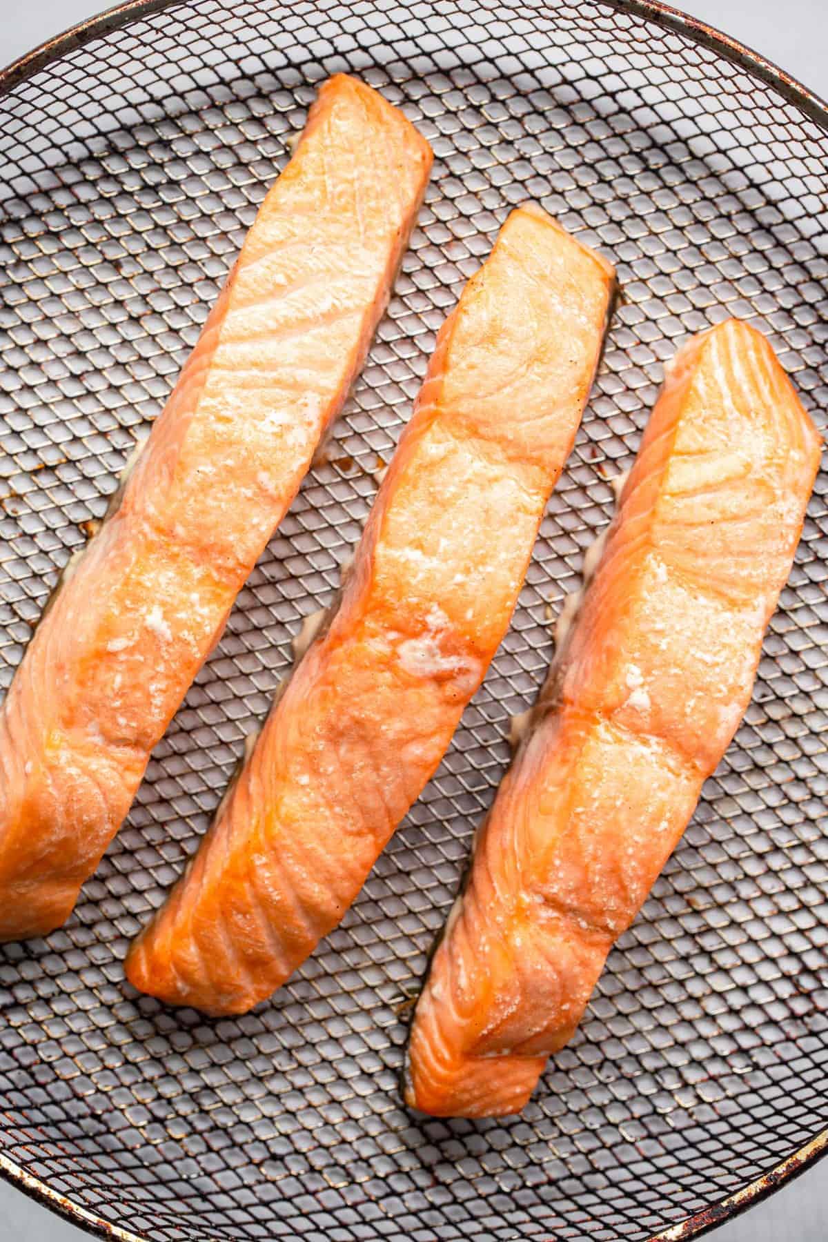 Salmon in the air fryer cooked on a mesh plate ready to eat