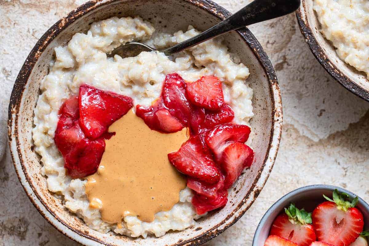 cauliflower oats on bowl with strawberries and peanut butter