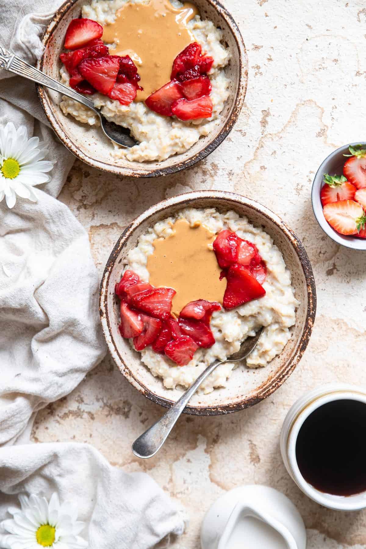 cauliflower protein oats in a small bowl with toppings and coffee