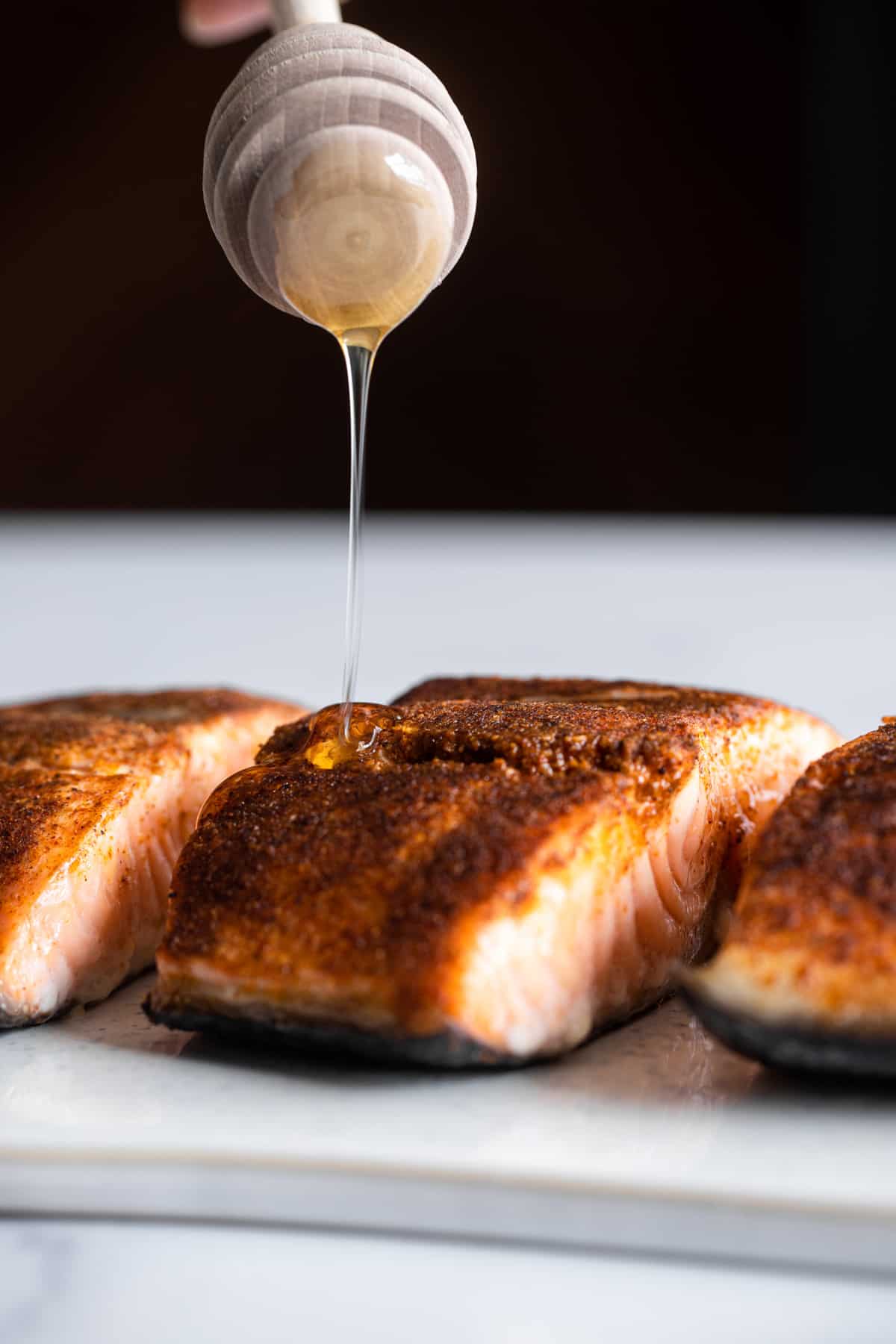Honey Cajun Salmon on a plate being drizzled with honey