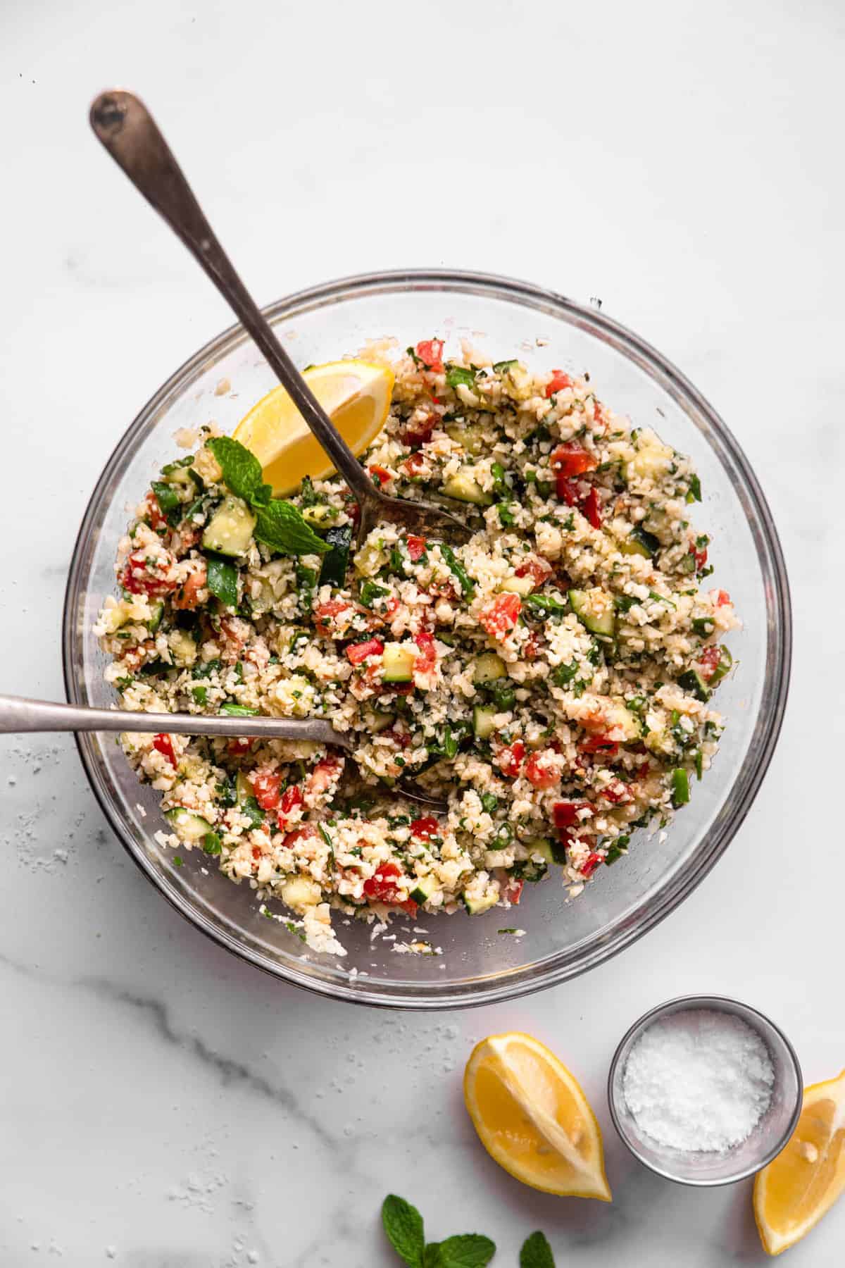  Tabbouleh Paleo in a mixing bowl with spoons and lemon