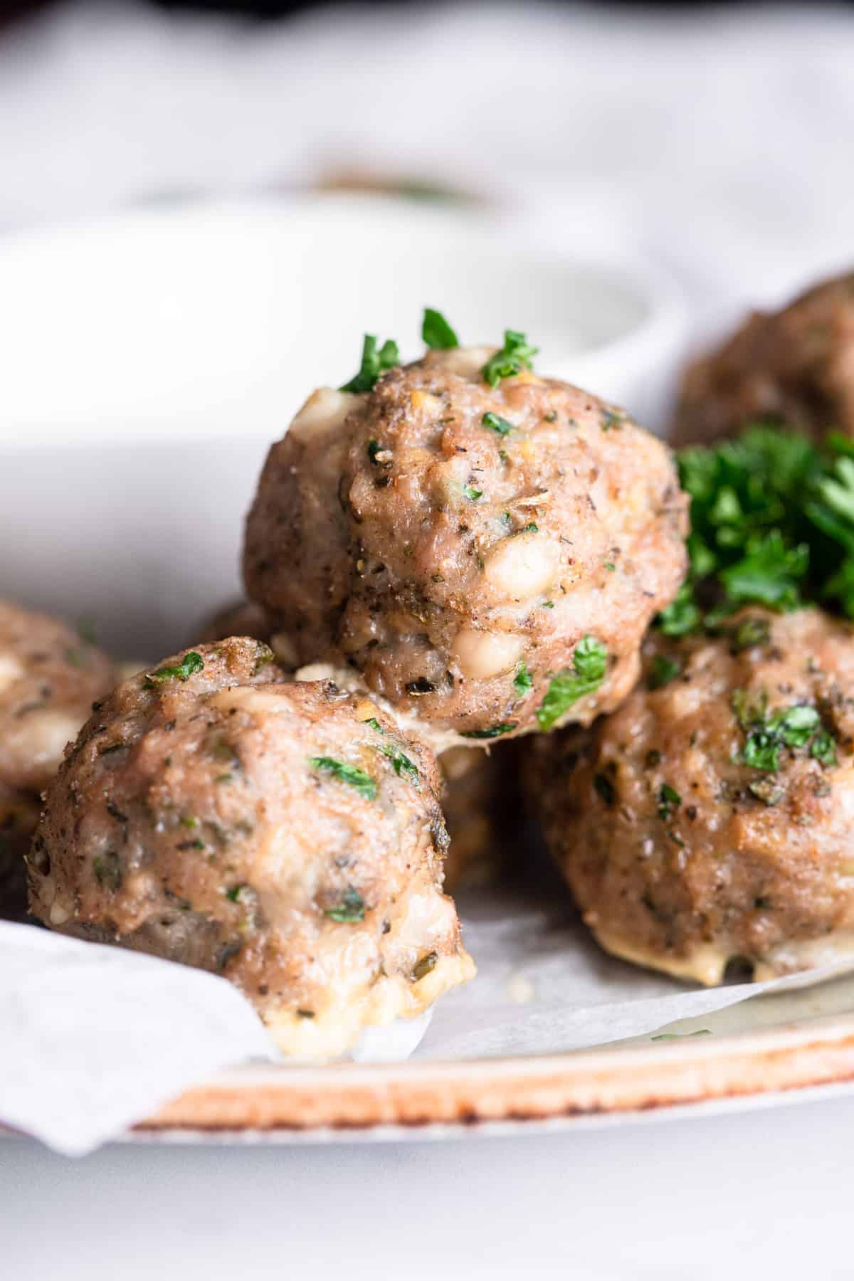 Baked greek turkey meatballs close up stacked on a plate