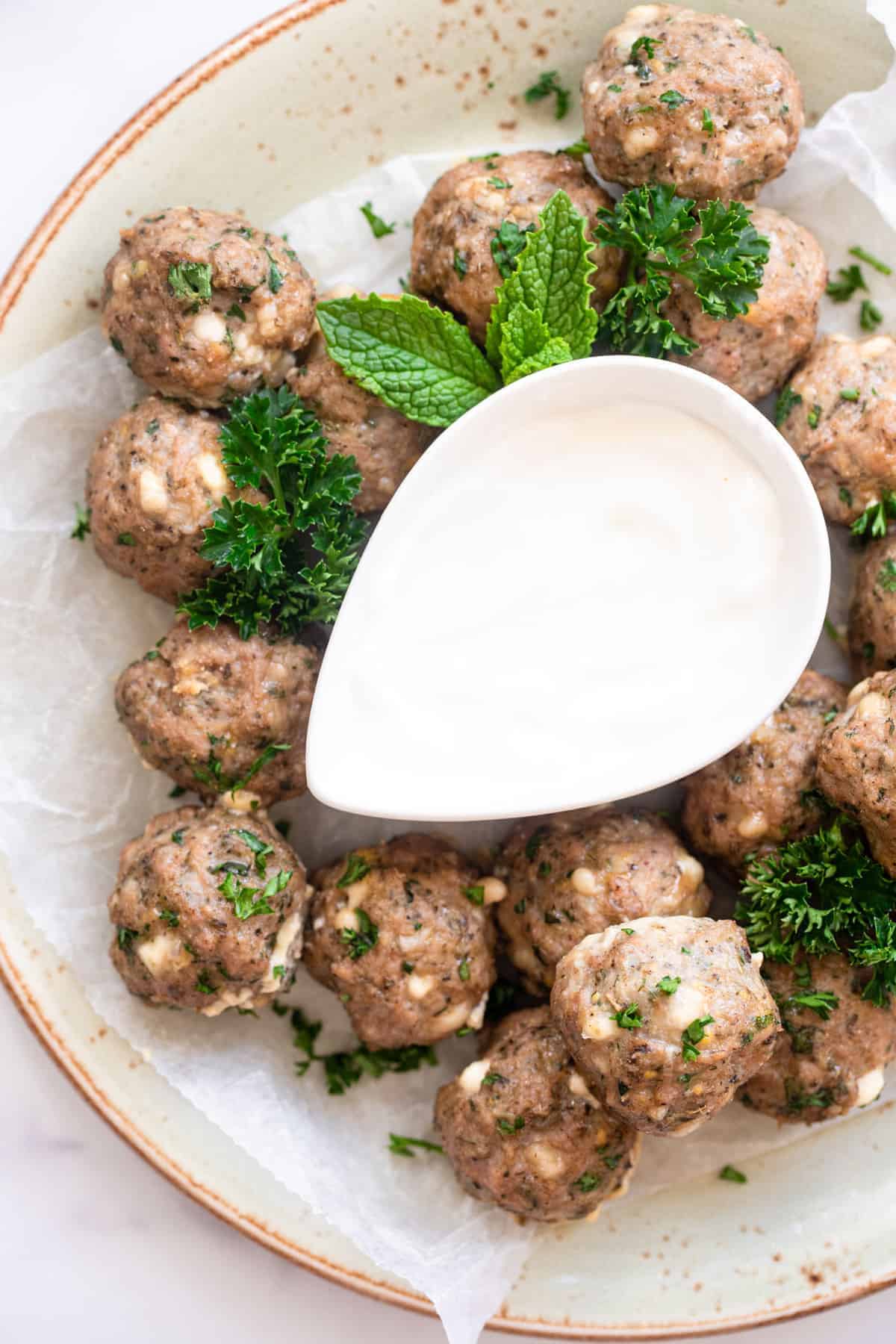  turkey meatballs on a plate with dip gravy boat