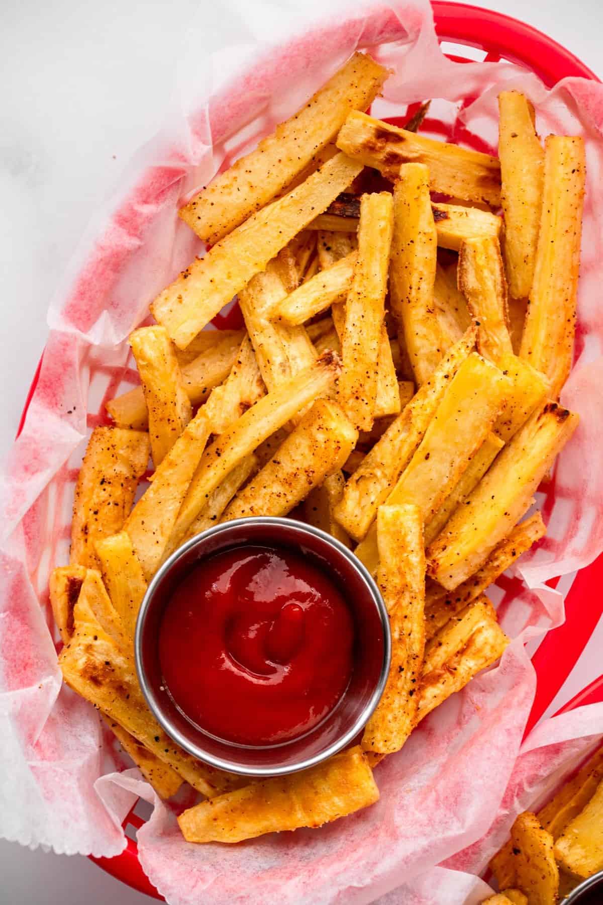 Parsnip Oven Fries in a basket with ketchup close up