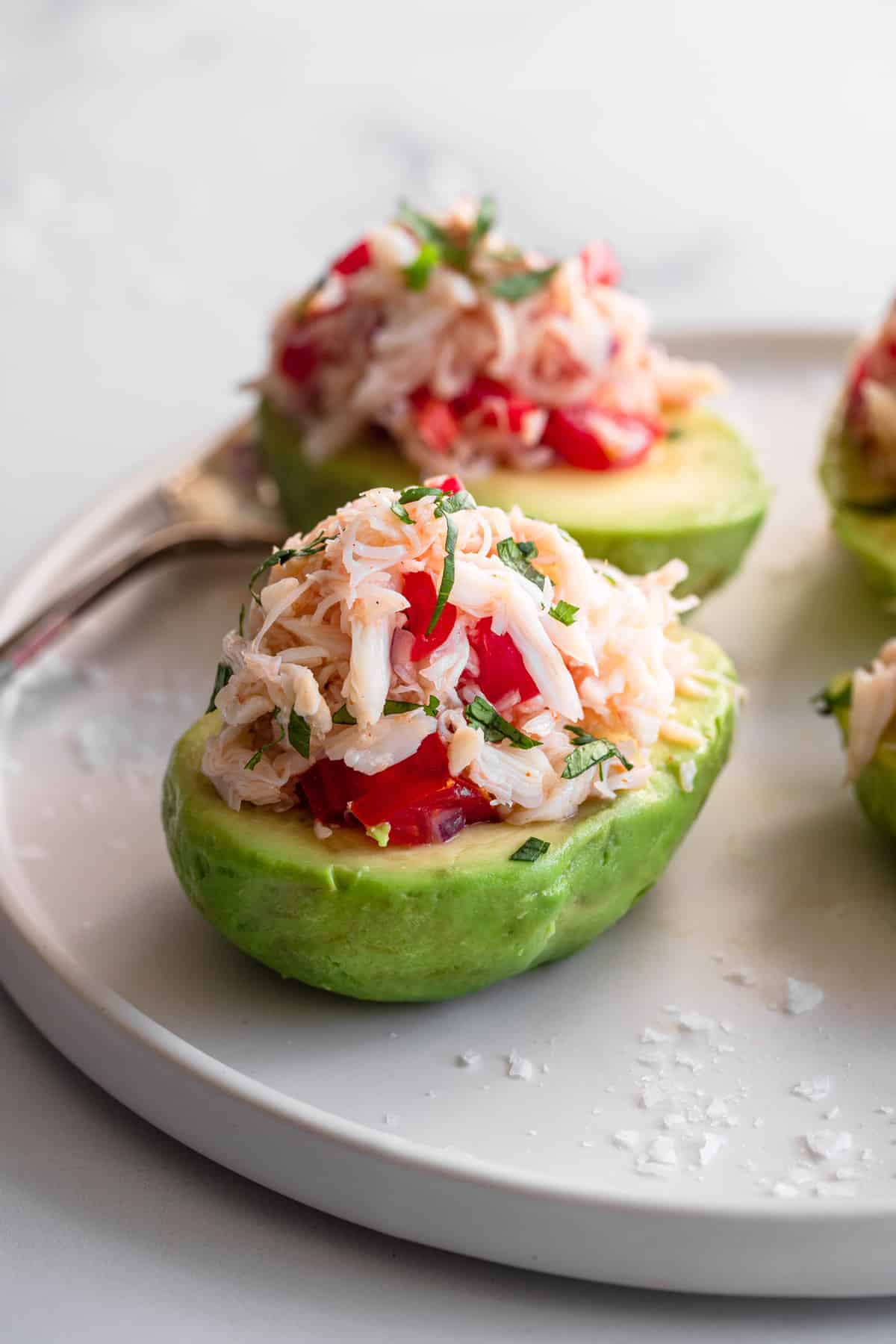 close up top view of crab avocado salad on a plate with fork