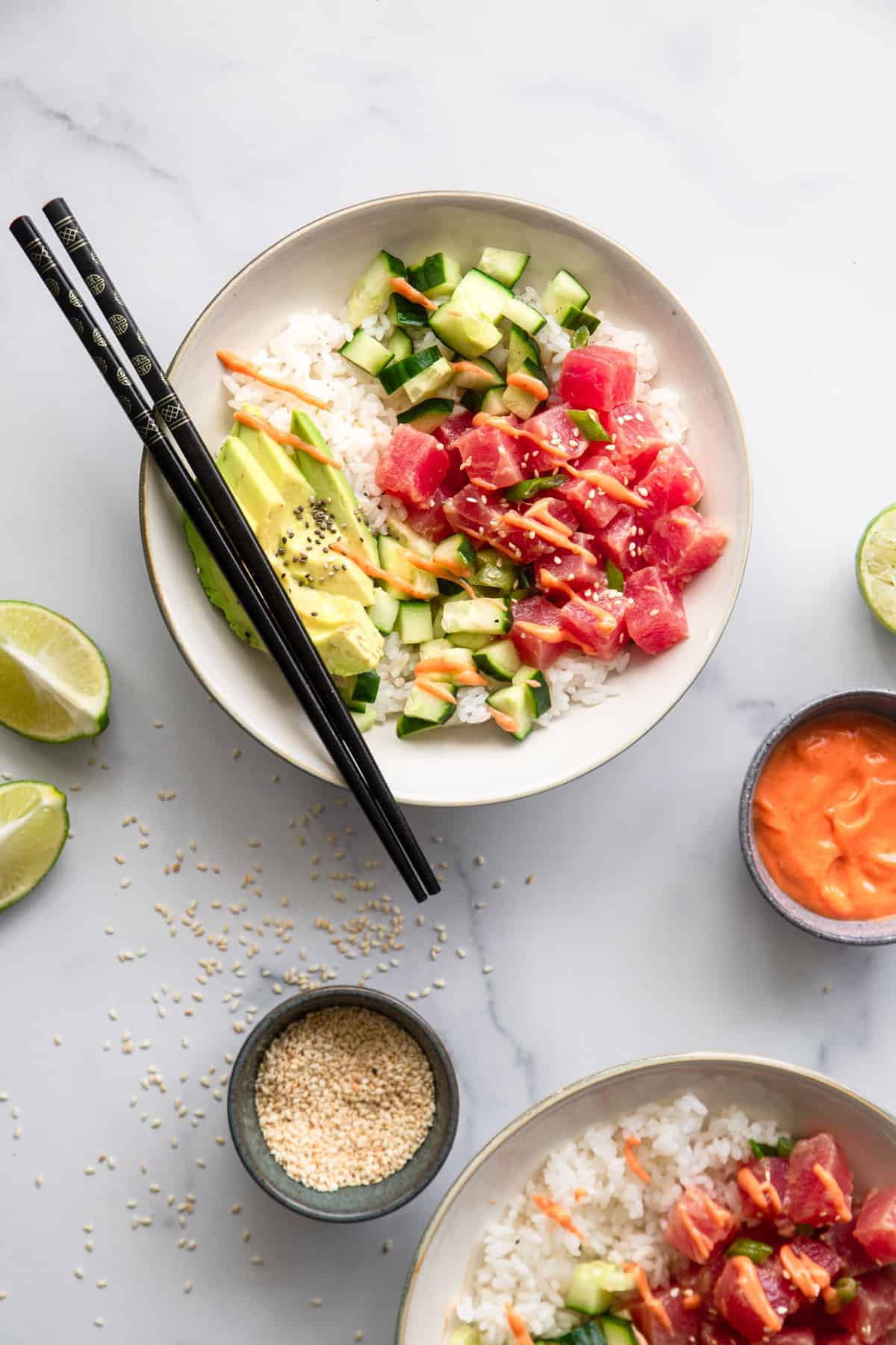 tuna poke bowl recipe on a bowl with chopsticks and sauces