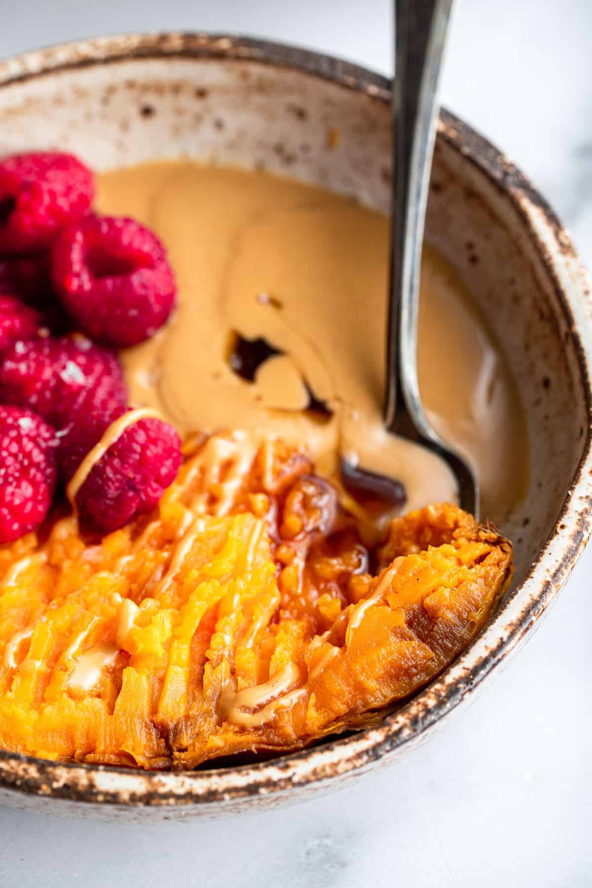 close up of sweet potato breakfast bowl with a spoon inside