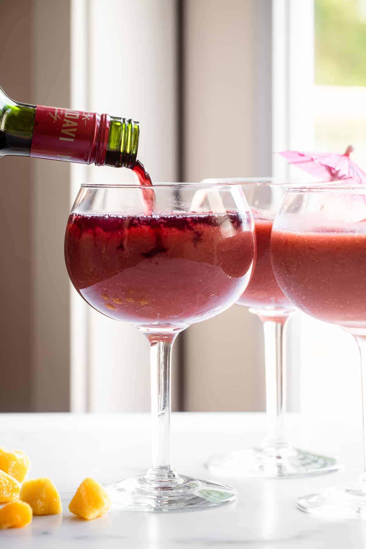 frozen sangria recipe in a glass with wine being poured in