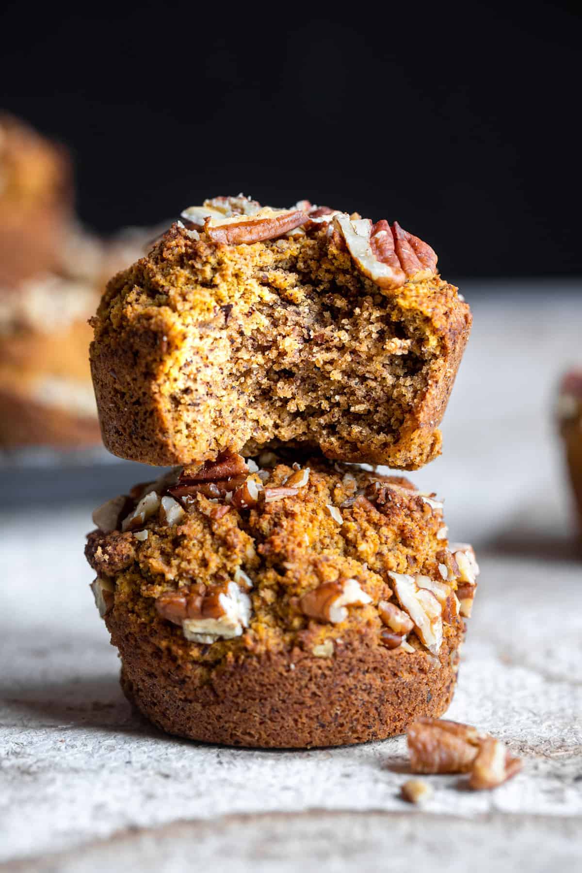 two keto pumpkin muffins stacked on top of each other