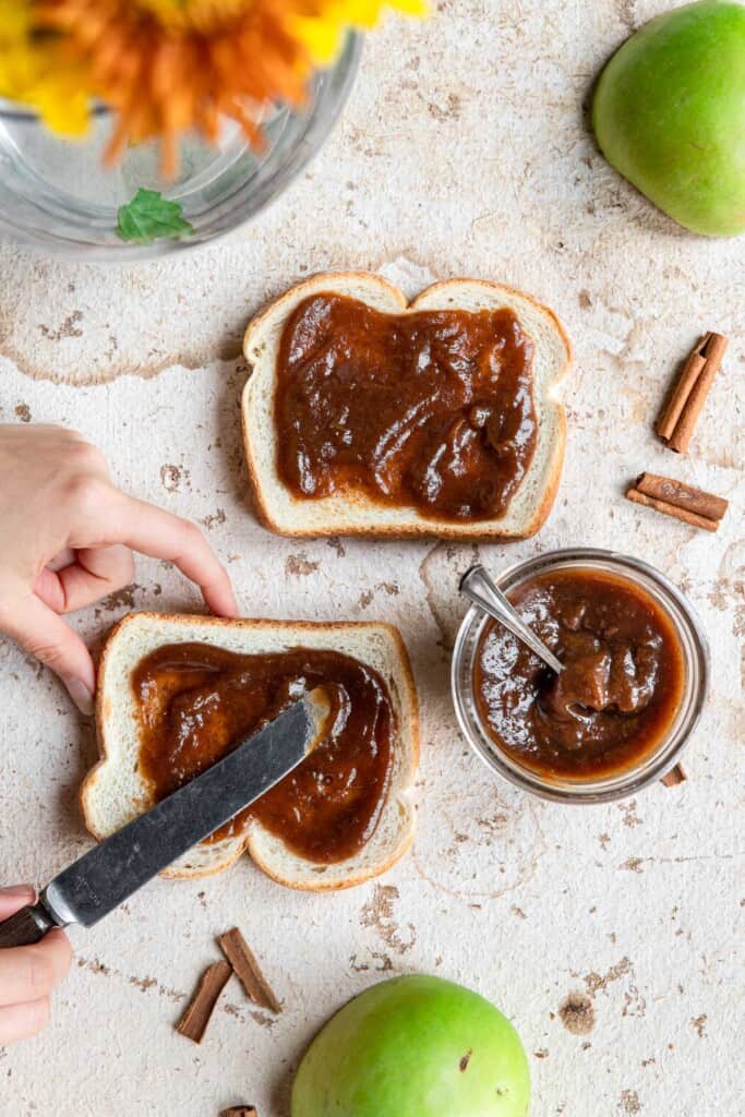 instant pot apple butter being spread on toast with a butter knife