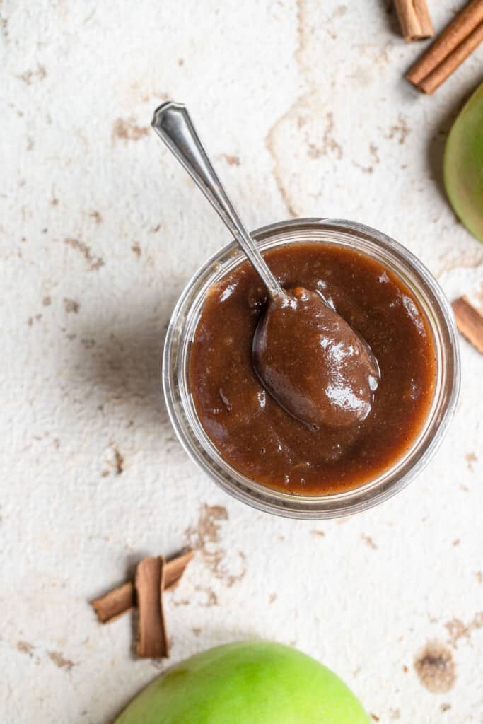 top view of instant pot apple butter in a small jar with a spoon