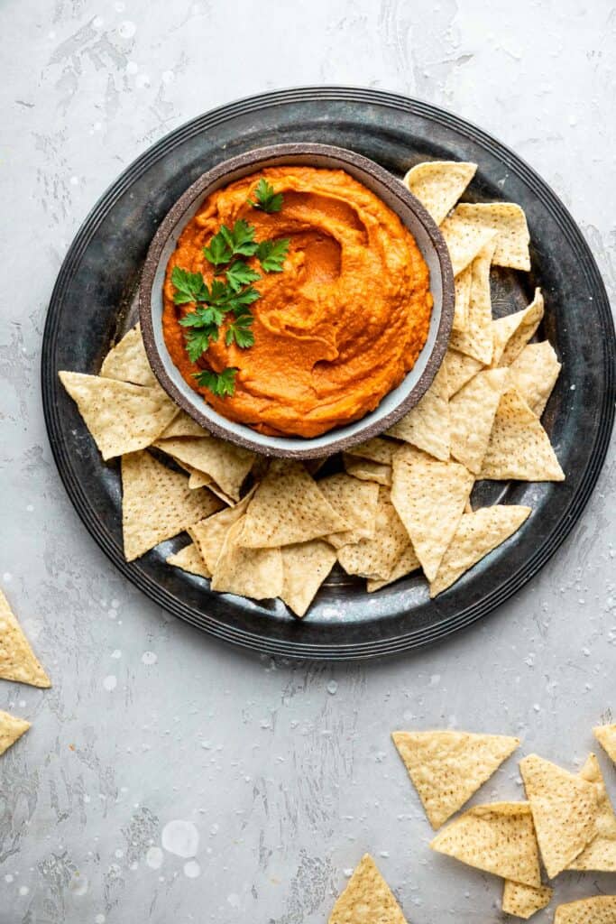 curry sweet potato almond butter dip in a bowl with chips on the side