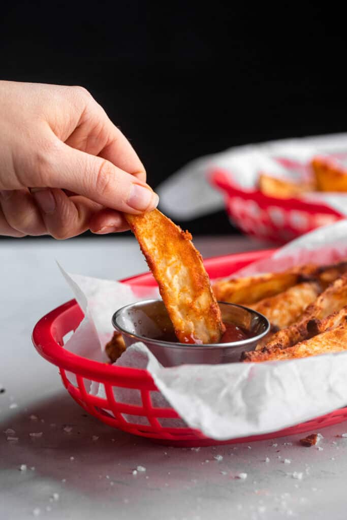 Air Fryer Potato Wedge being dipped into sauce