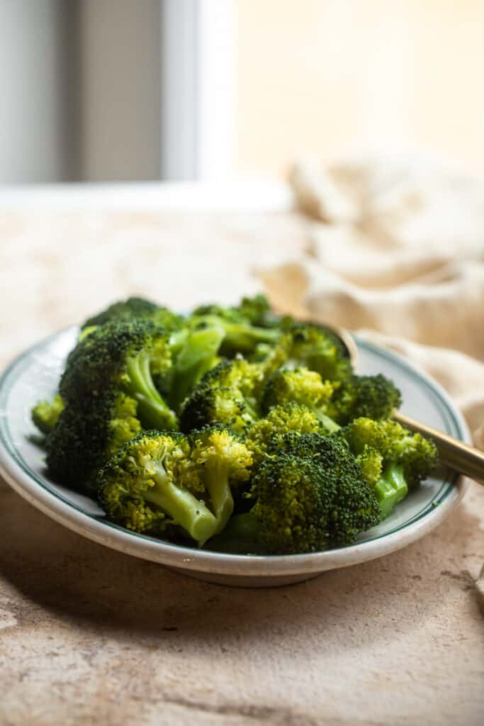 Instant Pot Steamed Broccoli on a serving plate with a fork