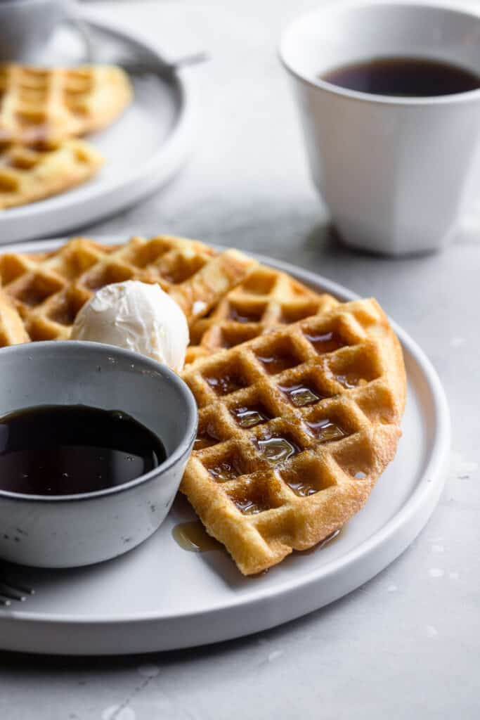 Dairy Free Waffles on a plate with a side of syrup