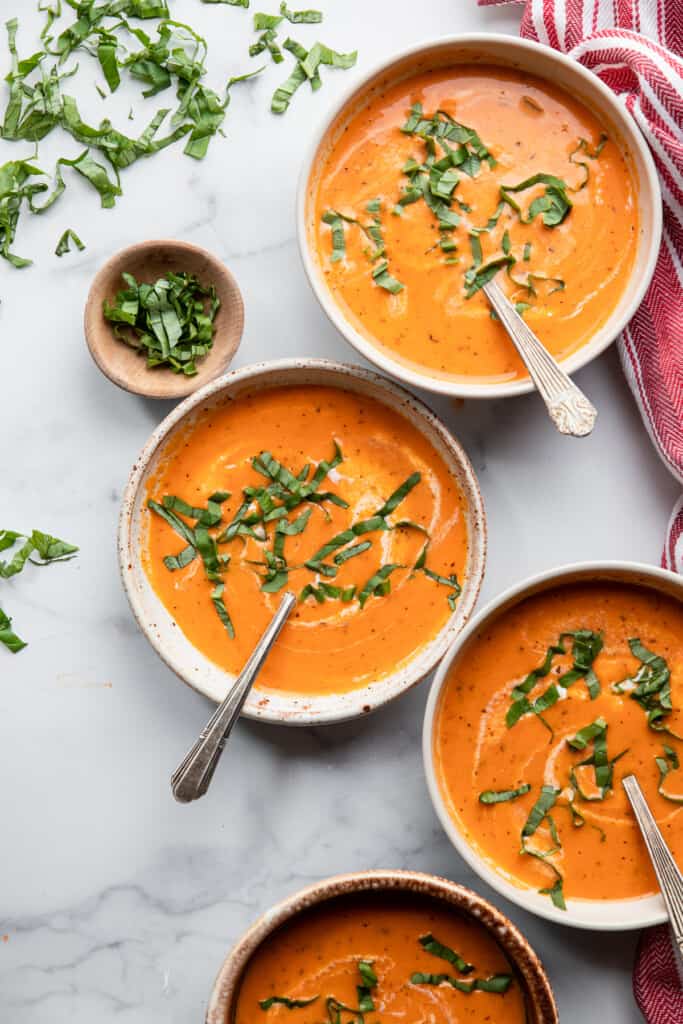 four bowls of Instant Pot Tomato Soup with basil