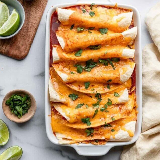 Instant Pot Chicken Enchilada in a dish on a table with toppings on the side