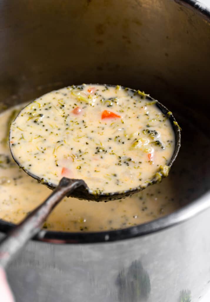 a ladle of Instant Pot Broccoli Cheddar from a pot
