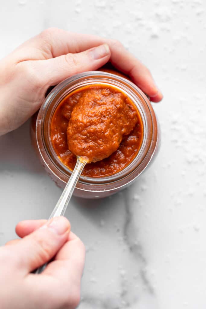 scooping Instant Pot Tomato Sauce out of a jar