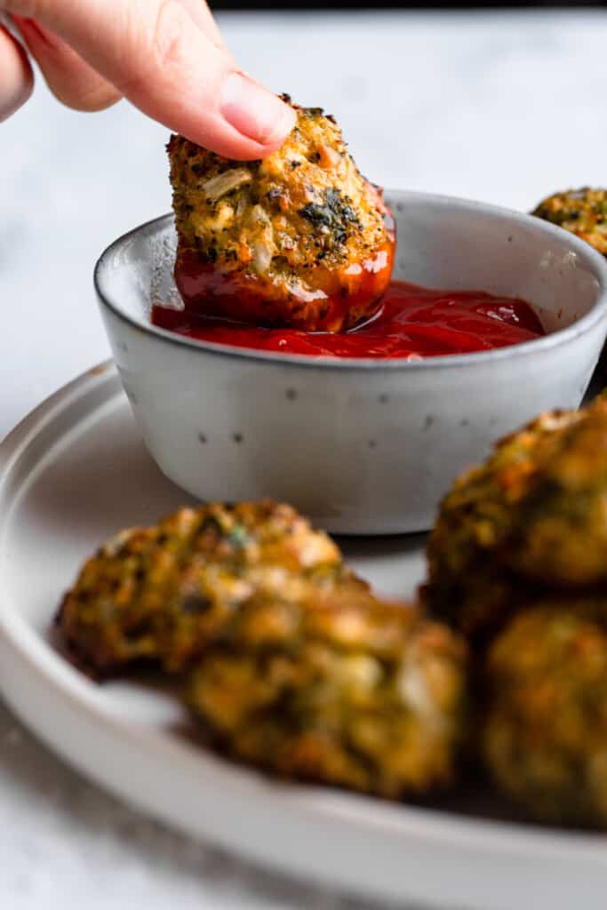 Broccoli bites are dipped in ketchup