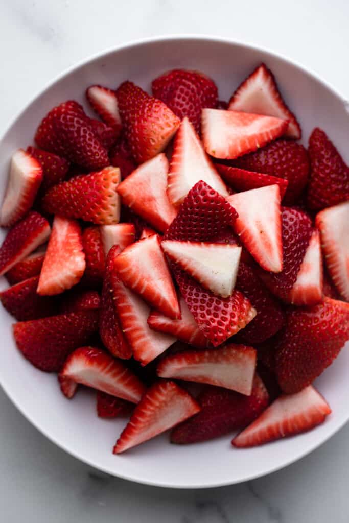sliced strawberries in a bowl ready to be roasted