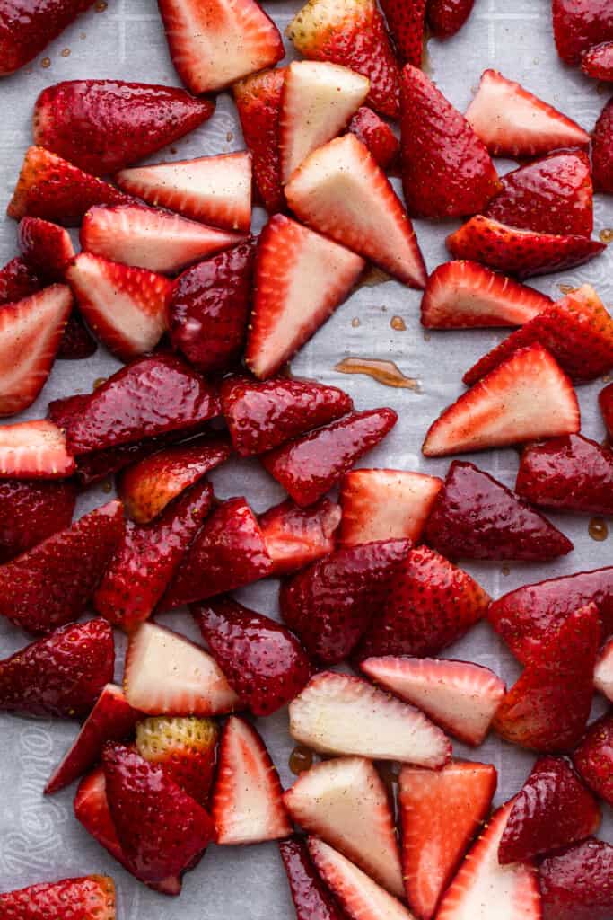 sliced strawberries arranged on a baking sheet for Roasted Strawberries