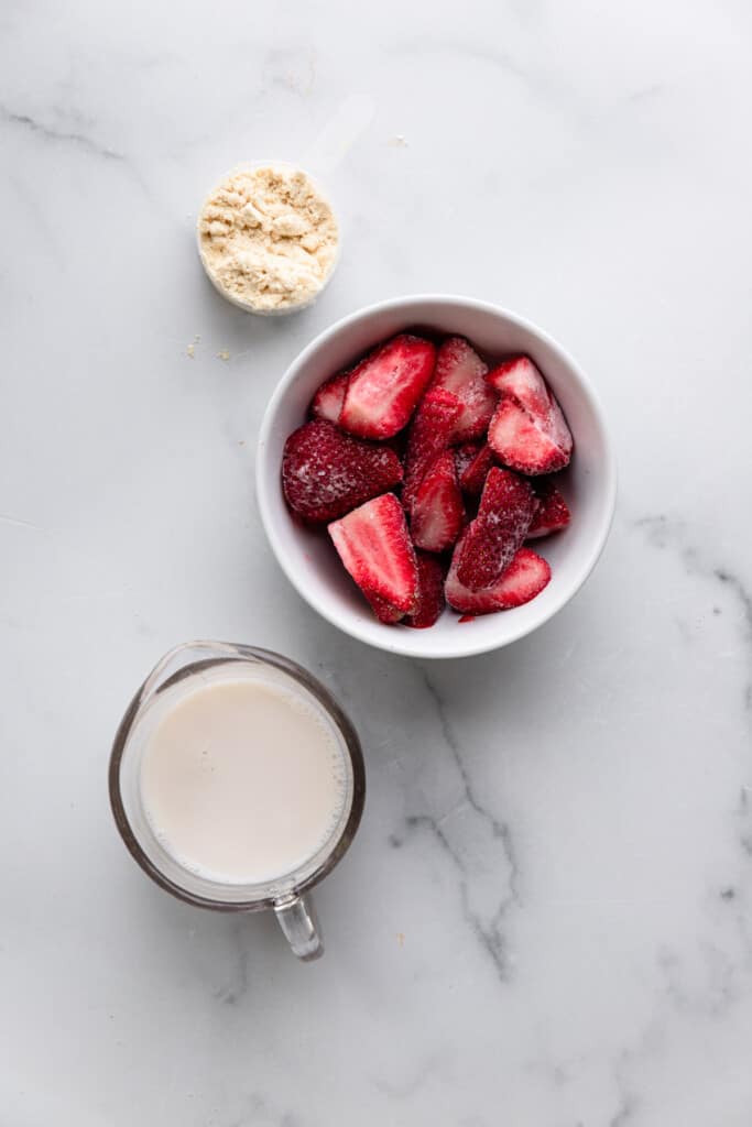ingredients in bowls for a Strawberry Protein Shake