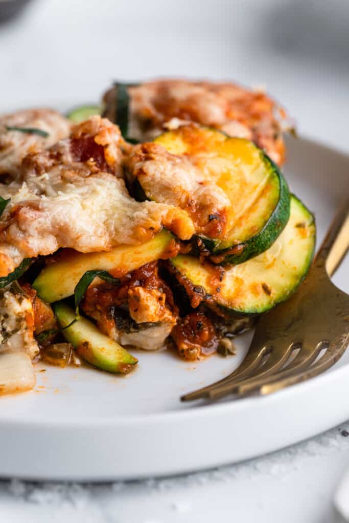a slice of Chicken Zucchini Casserole on a plate with a fork