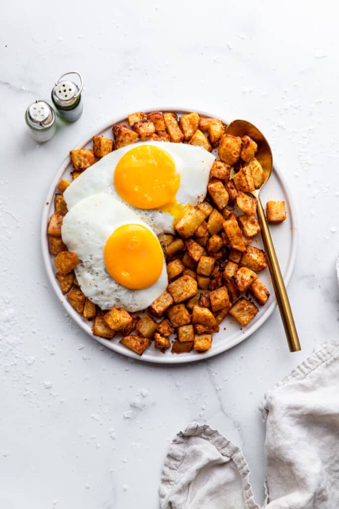 a plate full of Air Fryer Breakfast Potatoes with eggs on top