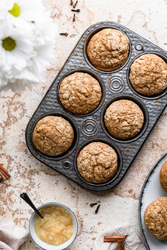 a muffin pan of Applesauce Muffins on a table