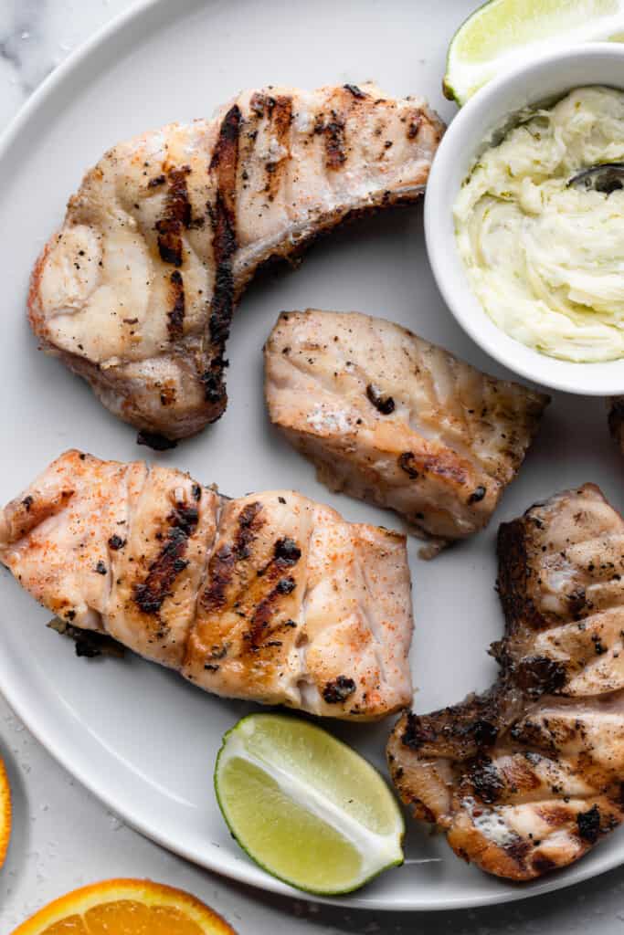 Grilled Grouper fillets arranged on a serving plate with lime butter