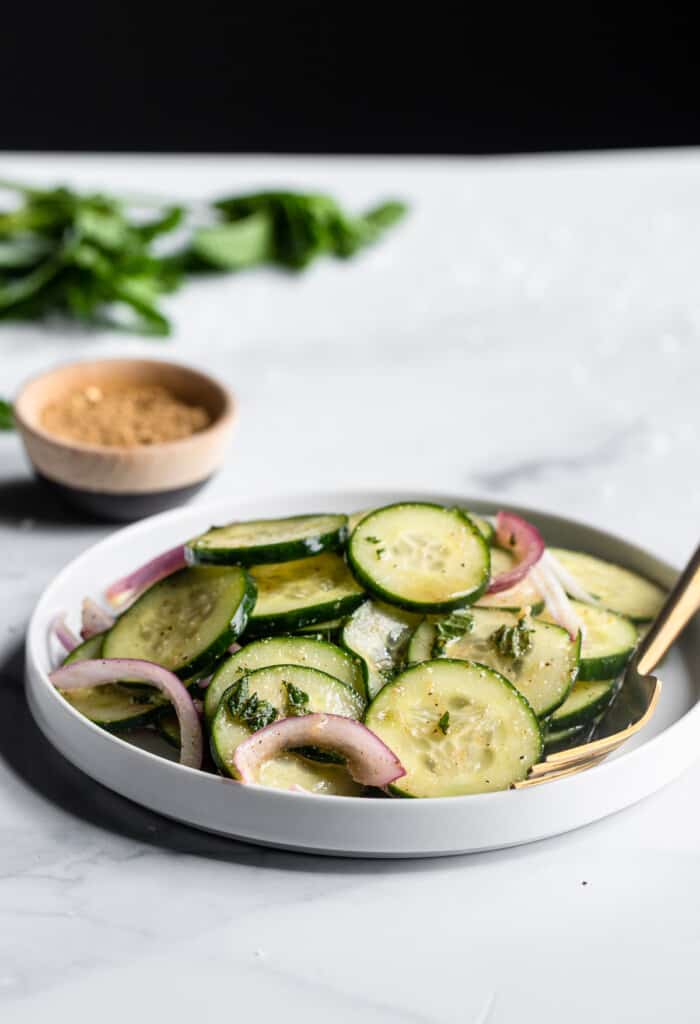 a bowl of Mediterranean Cucumber Salad on a table with spices