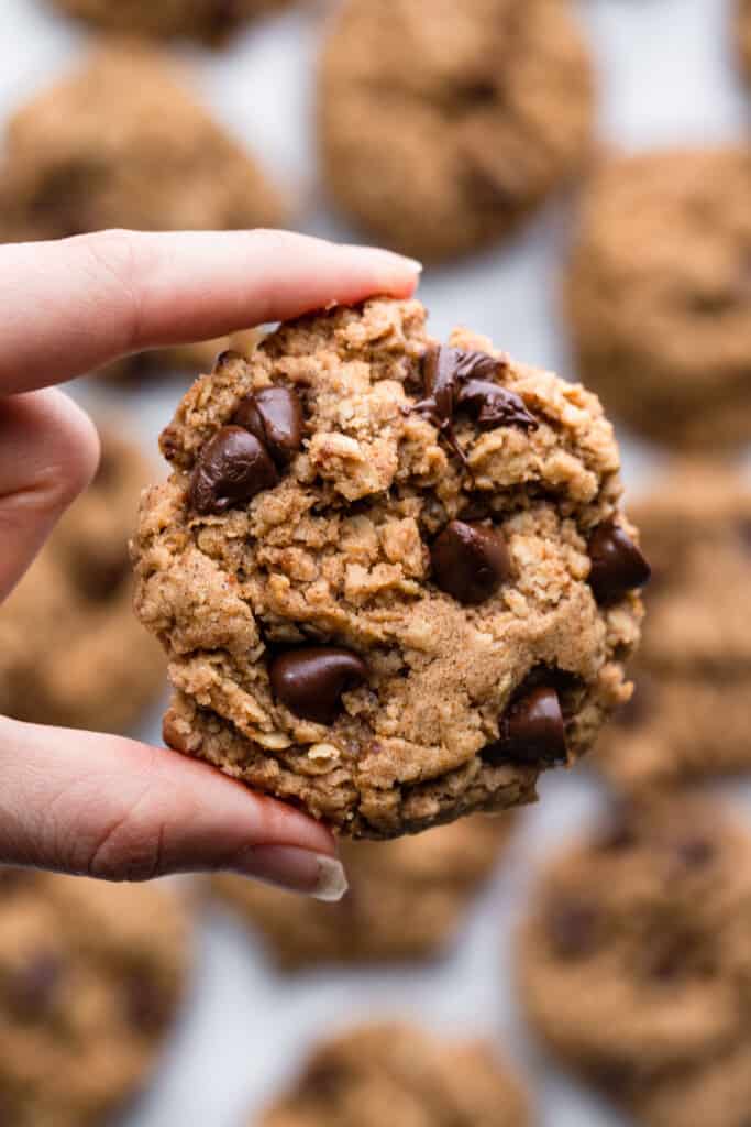 close up of a Vegan Oatmeal Chocolate Chip Cookies being held up
