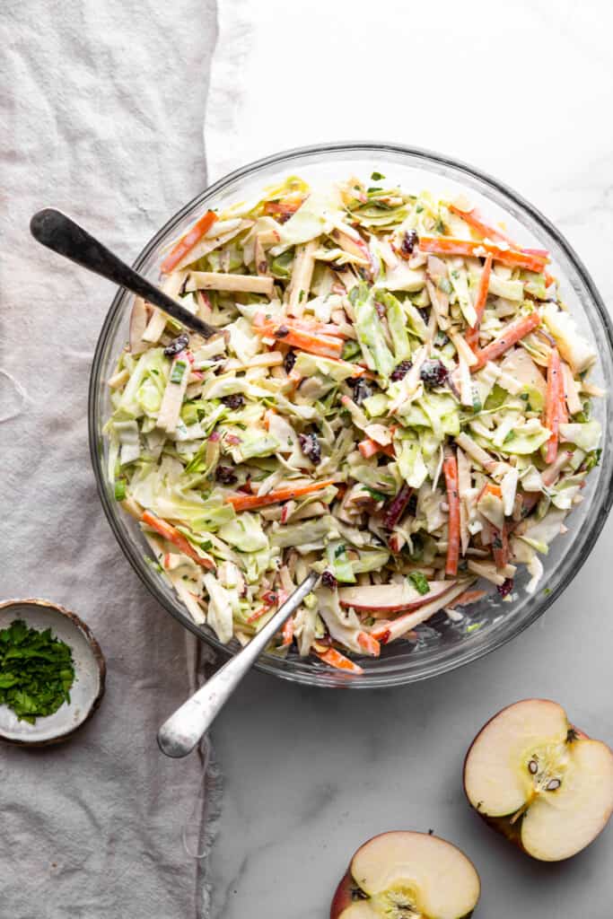 a serving bowl of Apple Coleslaw on a table