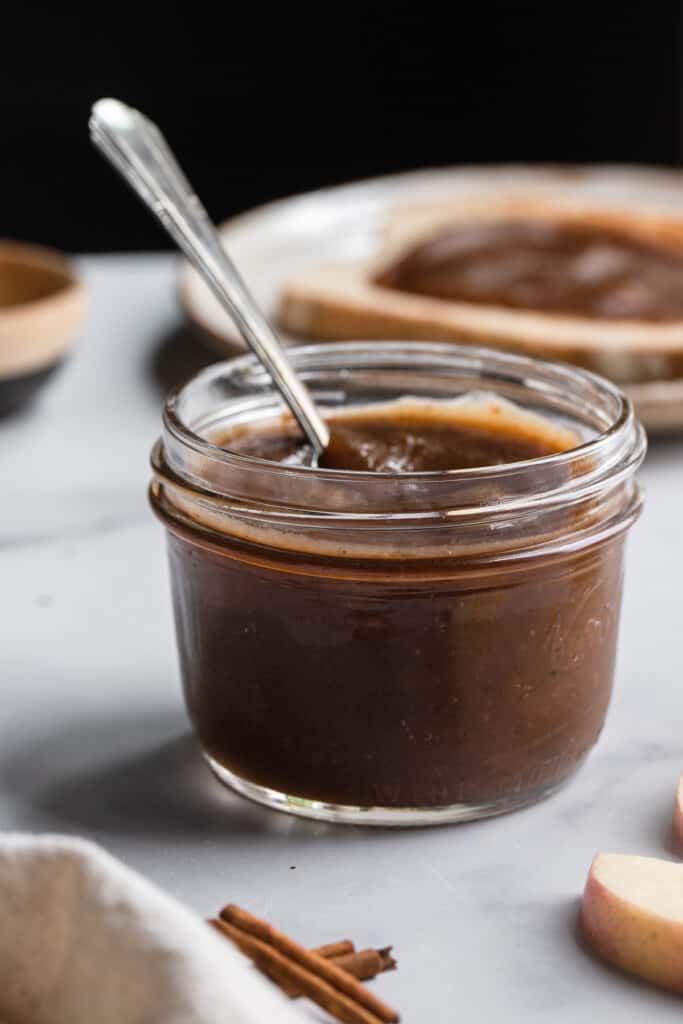 a jar of Slow Cooker Apple Butter with a spoon