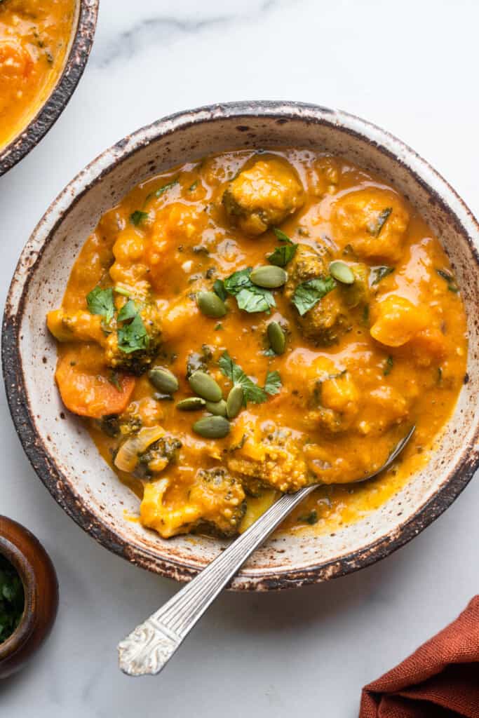 a hearty bowl of Thai Pumpkin Curry with a spoon