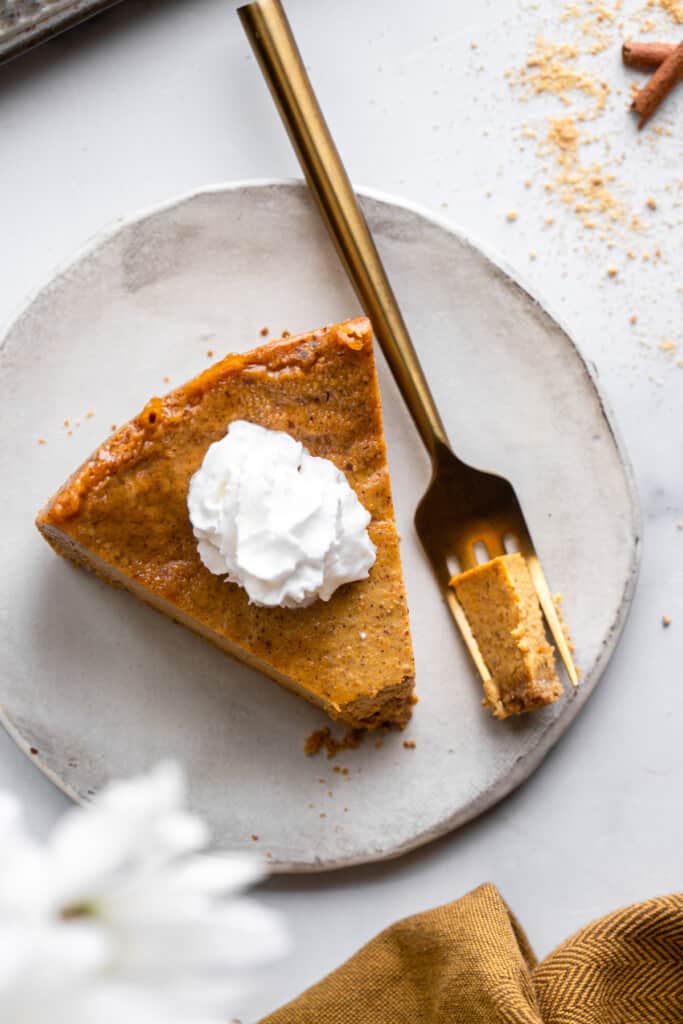 a slice of Vegan Pumpkin Cheesecake on a plate with a fork