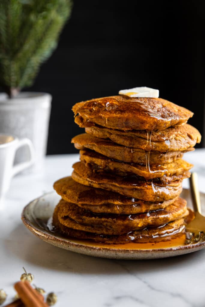 a stack of Vegan Pumpkin Pancakes on a plate with a fork