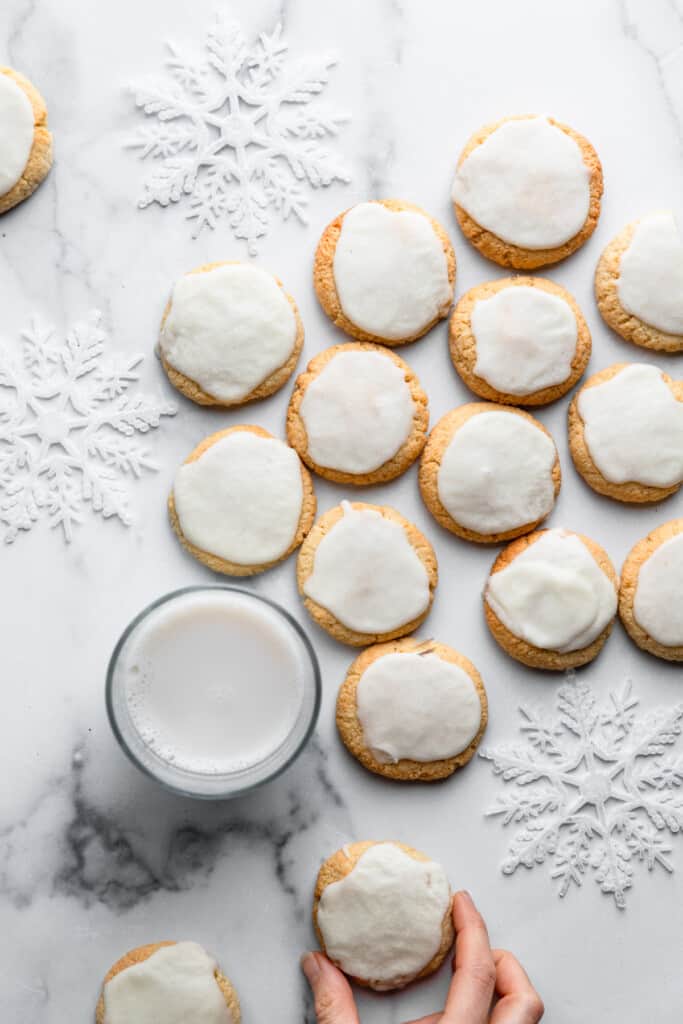 a batch of Almond Flour Sugar Cookies on a table with milk on the side