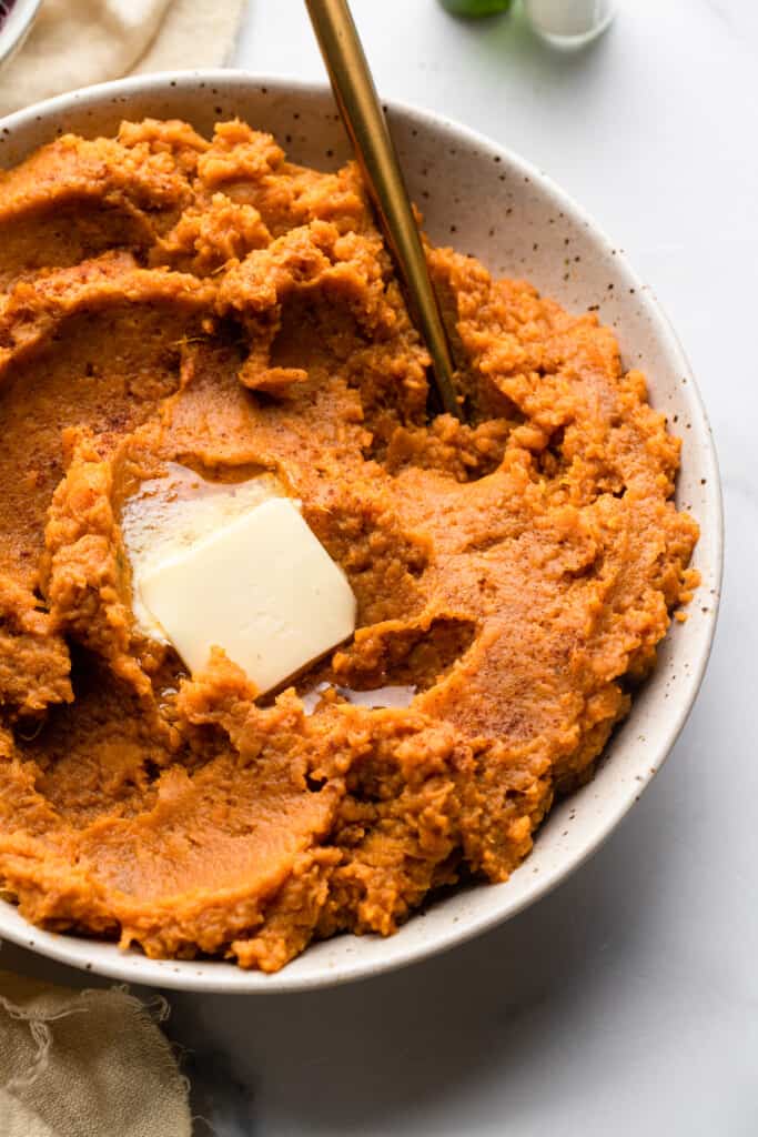 Healthy Mashed  Sweet Potatoes in a bowl with butter
