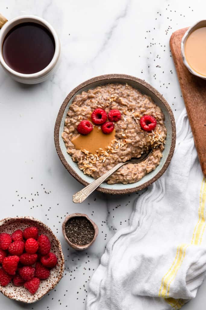 a bowl of Chai Seed Oatmeal with raspberries on the side