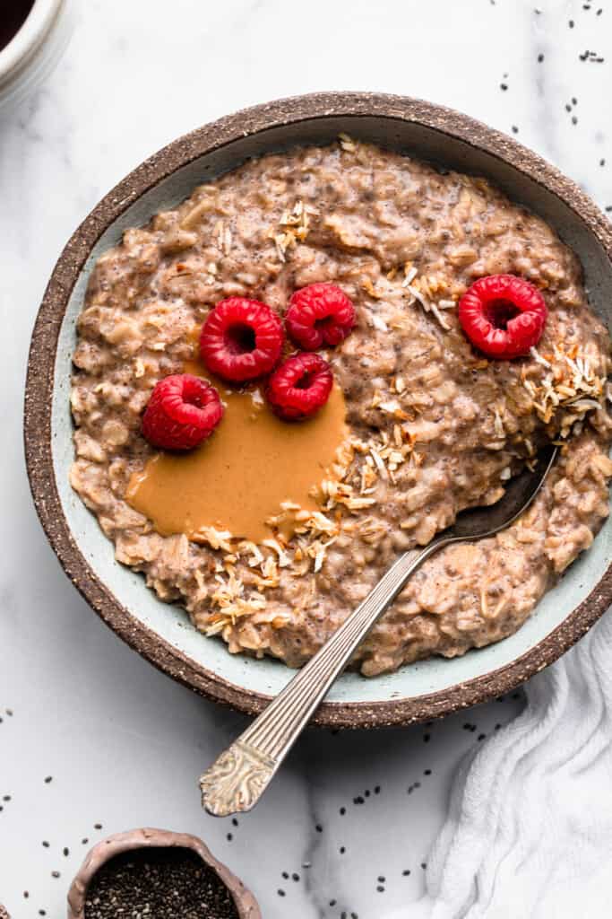 Chai Seed Oatmeal in a bowl with raspberries on top