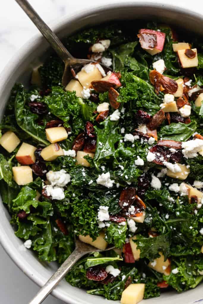 Kale Salad with Cranberries in a large bowl with serving spoons