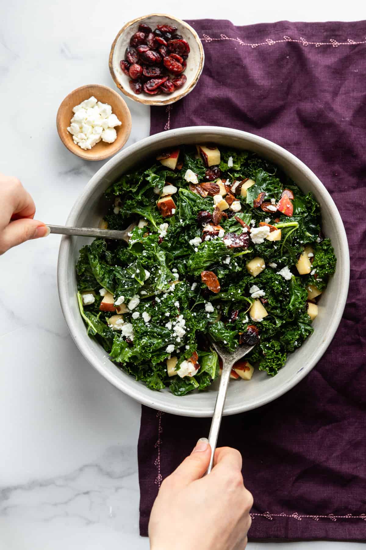 Kale Salad with Cranberries being stirred in a bowl