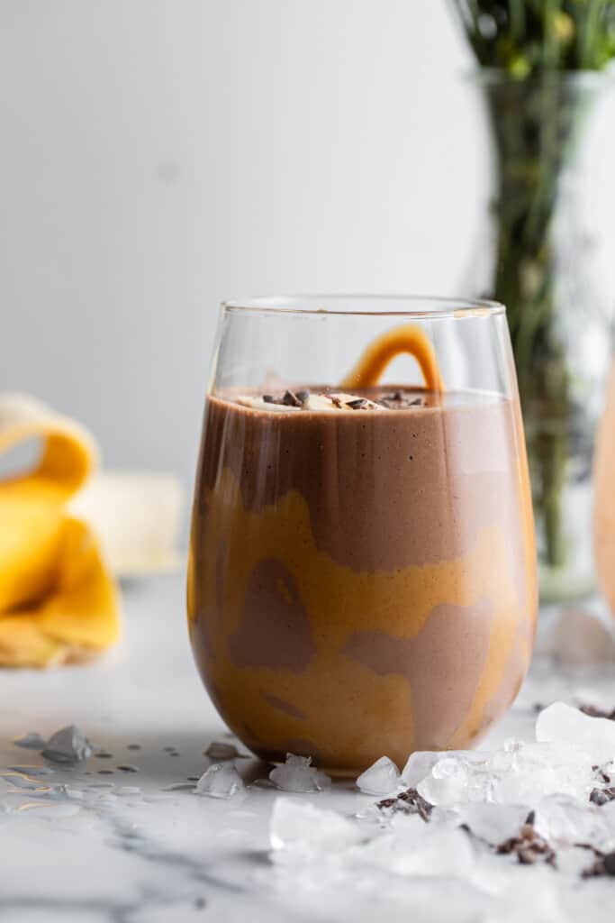 a short glass with Chocolate Peanut Butter Banana Smoothie in it