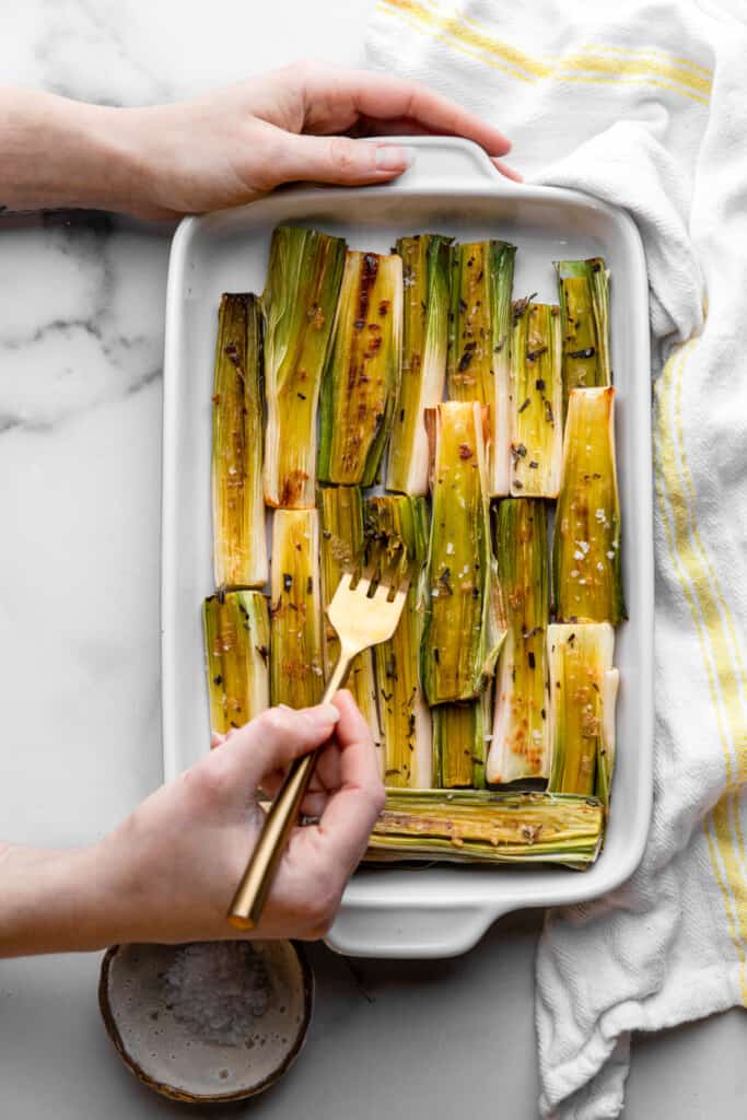 Roasted Leeks in a dish being picked up with a fork